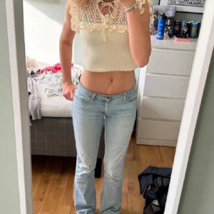 Beige stickad topp med spets och volang - Supersöt croppad topp från Zara i beige stickat material med spetsdetaljer och volang längs axlar och halsringning. Toppen har knyt framtill och är ärmlös, perfekt för en somrig look. Obs inte mina bilder men fråga bara för fler! Nästan aldrig änväd 😊Storlek M men passar mig som brukar ha xs/s 