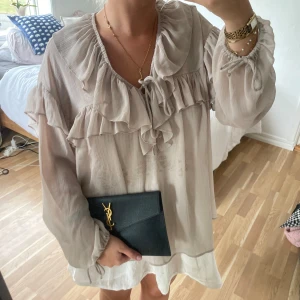 Ljus volangklänning med knyt - Supersöt kort klänning i ljus beige med volanger och knyt framtill. Långa, luftiga ärmar med resår och transparent känsla. Perfekt för dig som gillar romantisk och bohemisk stil. Materialet känns lätt och flowy🤎🤎