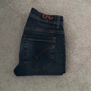Dondup jeans - Säljer ett par mörkblå jeans från Dondup med klassisk femficksdesign och snygga kontrastsömmar. Jeansen har normal passform och raka ben. Perfekta för dig som gillar stilrena och tidlösa jeans. Storlek 29, äkthetsbevis från Vestiaire. 