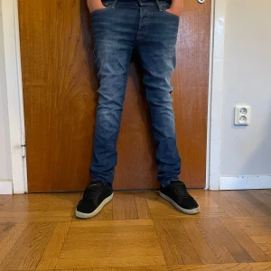 Jack & Jones Slim Fit jeans blå 28/32 - Slim fit jeans från Jack & Jones i snyggt tvättad blå denim. Modellen heter Tim och har klassisk femficksdesign, normalhög midja och smal passform hela vägen ner. Perfekta för dig som gillar en stilren och modern look. Köpta för 1000kr dem är knappt använda så mitt pris är 299