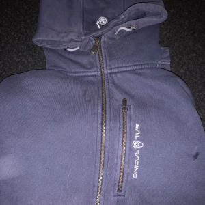 Sailracing hoodie - Mörkblå hoodie från Sail Racing med huva och snörning framtill. Pm för fler bilder 