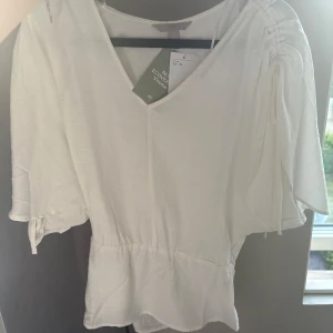 Topp med indragen midja - Superfin topp\blus från Hm med band man kan dra åt vid axlarna ☺️xs men ganska stor i storleken , aldrig använd med prislappen kvar ☺️