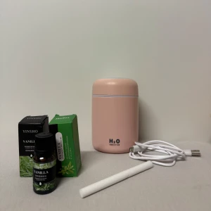 Rosa luftfuktare med ledljus, USB och olja - Säljer ett kompakt rosa  luftfuktare med ledljus med USB-sladd. Medföljer vaniljdoftande eterisk olja från Yinsho och Hankey. Man får med laddaren, 3 oljor och 2 filters. Den är helt oanvänd. 