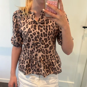  Leopard blus från Kappahl  -  Jag säljer denna leopard blus från Kappahl. Den har puffiga armar och tre rosetter fram till
