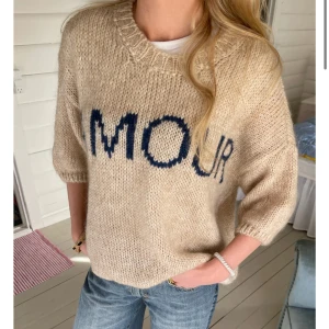 Söt stickad tröja - Supermysig beige stickad tröja med mörkblå texten 'AMOUR' framtill. Tröjan har en loose passform, kortare ärmar och bred ribbad rund halsringning. Perfekt att slänga på sig för en chill och snygg look😊😊😊skriv om fler bilder😇