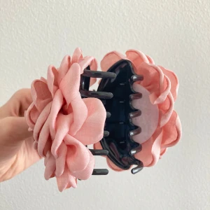 Rosa blommig hårklämma från Nelly - Superfin hårklämma med stora tygblommor i ljusrosa. Har inte haft på mig den alls, passar inte min hårfärg som du ser på bilden. Klämman är i plast med mjuka blommor i tyg som ger en romantisk vibe. Fick den gratis från Nelly lol