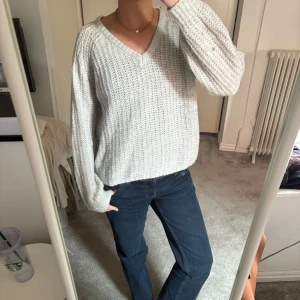 Grå stickad tröja från 157 - Säljer en mysig grå stickad tröja från 157 med v-ringning. Tröjan har långa ärmar och en avslappnad passform, perfekt för kyligare dagar. Den är både stilren och bekväm, ett måste i garderoben! 💫