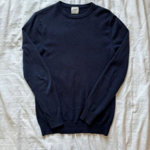 Mörkblå kashmirtröja från John Henric - Säljer en elegant mörkblå kashmirtröja från John Henric gjord av 100% kashmir. Det är skador på armana på tröjan. Kontakta gärna för mer information eller bilder!