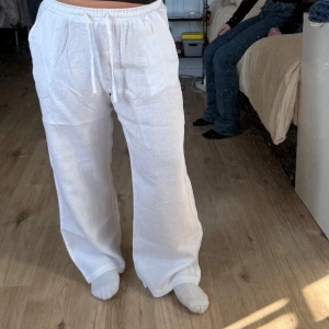 Vita linnebyxor från Madlady - Säljer ett par vita linnebyxor från Madlady i storlek S. Byxorna har en loose passform med elastisk midja och snörning för extra komfort. Perfekta för en avslappnad stil.