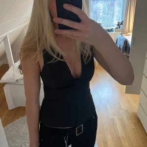 Svart topp från Zara - Snygg svart satin topp från Zara med v-ringning. Den är aldrig riktigt använd, endast testad. Säljer den då jag redan har en i en annan färg!