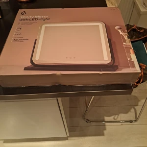 Sminkspegel med LED-ljus - Snygg och praktisk sminkspegel med justerbart LED-ljus. Perfekt för att få till den rätta belysningen vid sminkning. Spegeln har en modern design och är enkel att använda med touch-kontroller. Mått: 52 x 44 x 12 cm.