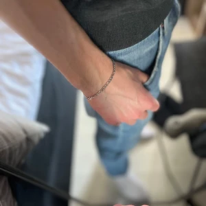 Silverfärgat armband - Snyggt och enkelt silverfärgat armband med kedjedesign. Perfekt för att ge en stilren touch till din outfit. Lätt att matcha med andra smycken.