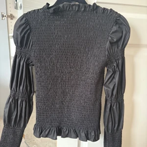Ribbad topp - Svart Ribbad topp med puffärmsliknande ärmar från Y.A.S! Använd en gång så i fint skick storlek M men skulle säga att den passar XS-M