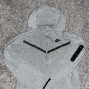 Grå Nike tech - Säljer nike tech fleece grå.Storlek XL barn, jag är själv 175cm är den funkar för mig, men bara inte min stil. Inga skador. Skriv gärna om frågor😃