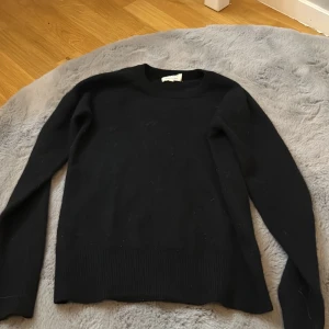 Svart tröja från Soft Goat - Small men liten i storlek. Mer som XS. Säljer en stilren svart tröja från Soft Goat. Tröjan har en klassisk design med långa ärmar och rund halsringning. Perfekt för en elegant och bekväm look.