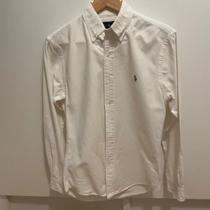 Ralph Lauren Skjorta  - Vit skjorta från Ralph Lauren i Stl S. Använd ett fåtal gånger, skick 9/10. Nypris ca 1500kr. Hör av dig vid frågor eller funderingar! 