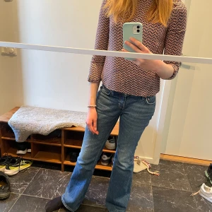 Söt blus från Esprit - Jättefin mörkblå blus med orangefärgat bladmönster från Esprit. Passar perfekt nu till våren! Den har en boatneck krage och en fin knappdetalj på trekvartsärmarna. 100% viskos.