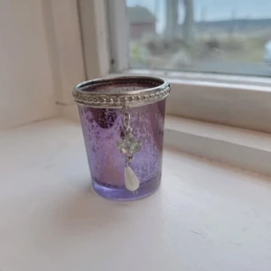 Lila ljuslykta med ängel 💜🤍 - En lila ljuslykta med en hängande ängel. Har använts några gånger och har några tecken på användning både insidan och utsidan. FÖRST TILL KVARN!🤍💜(BUNDLERABATT VID KÖP AV FLER ARTIKLAR!)