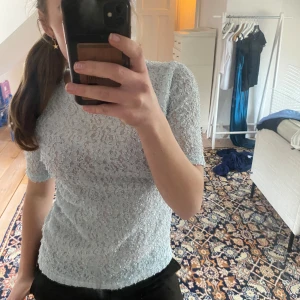 Ljusblå t-shirt - Säljer en ljusblå blus i spets med korta ärmar. 