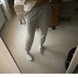 Grå mjukisbyxor med snörning - Säljer ett par grå mjukisbyxor med snörning i midjan och muddar vid bensluten. Perfekta för chill dagar hemma eller när du vill vara extra bekväm. Klassisk passform och mjukt material.