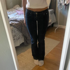 Mörkblå bootcut jeans - Snygga mörkblå jeans med bootcut passform och klassiska fem fickor. Jeansen har låg midja.