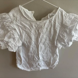 Vit puffärm blus från Zara - Supersöt vit blus från Zara med stora puffärmar och rund halsringning. Toppen är i mjuk bomull och har en enkel, stilren look som passar perfekt till jeans eller kjol. Perfekt för dig som gillar trendiga detaljer och en clean vibe.
