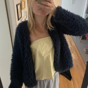 Mörkblå pälsjacka - Gina Tricot - Fluffig och trendig mörkblå pälsjacka/kofta från Gina Tricot i pälsimitation. Jackan har lång ärm och är tillverkad i mjukt syntetmaterial som ger en cool och mysig look. Använd några gånger men passade inte riktigt min personliga stil💕jackan är i st.L men jag som har S tycker den sitter superbra beroende på hur man vill ha den så skriver in S som storlek i annonsen☺️