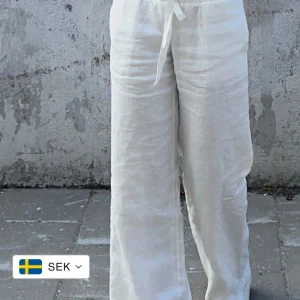 Vita linnebyxor från Alobha labels - Snygga och luftiga vita linnebyxor med bred resår i midjan och snörning framtill. Byxorna har en rak och relaxed passform med raka ben, perfekta för varma dagar. Nypris 799 kr, använd flera gånger men i väldigt bra skick. 