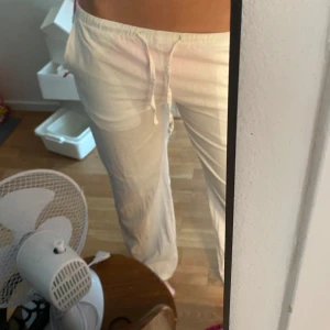 Vita linnebyxor med snörning - Säljer ett par lågmidjade vita linnebyxor med avslappnad passform och snörning i midjan. Det rosa på sidorna är bikini så medföljs ej med. Perfekta för varma dagar och riktigt sköna att bära. Är i storlek 158-164 men passar mig som bär Xs/S
