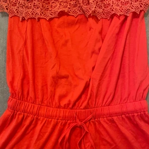 Röd kort jumper från Ellos - Superfin röd kort klänning från Ellos med offshoulder och spetsdetaljer upptill. Klänningen har resår och knytband i midjan för en snygg passform. Perfekt för sommardagar när du vill sticka ut lite extra.