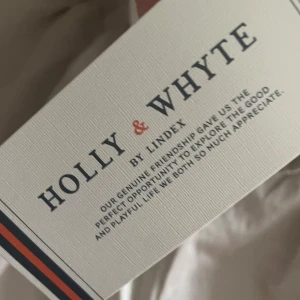 Beige volangkjol Holly & Whyte - Supersöt beige kortkjol från Holly & Whyte med volang och dragkedja bak. Kjolen har en lätt utsvängd form och är gjord i bomull, perfekt för en fräsch och stilren look.
