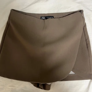 Brun kjol med insydda shorts från Zara - Jätte snygg stilren kjol från Zara! Perfekt över en body 