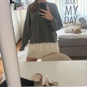 Prickiga volangkjol med hög midja - Supersöt vit volangkjol med svarta prickar och volangdetaljer. Mellan midjade med bred, smockad resår i midjan för extra komfort. Jättesöt och bra till sommaren, har även shorts under vilket är skönt