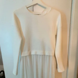 Vit långärmad klänning från Vila - Superfin vit klänning med långärmad ribbad överdel och flowy kjol i tunt tyg. Enkel och stilren design med rund halsringning, perfekt för dig som gillar en clean look. Aldrig använd vilket är väldigt synd då det är en fin & söt klänning! Finns en liten fläck (se bild), klänningen kommer självklart att tvättas innan den ska fraktas iväg till nästa ägo och kommer meddela om fläcken försvinner eller inte o då kan pris diskuteras! 
