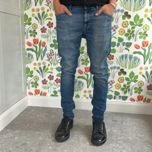 Blå  jeans herr - Snygga blå jeans med smal passform och klassisk femficksdesign. Jeansen har en något tvättad look och sitter tajt längs benen. Perfekta för dig som gillar en modern och stilren stil.