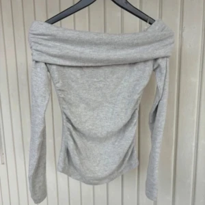 Ljusgrå offshoulder topp från Amisu - Säljer en ljusgrå långärmad offshoulder topp från Amisu. Mjuk och stretchig i materialet. Helt ny