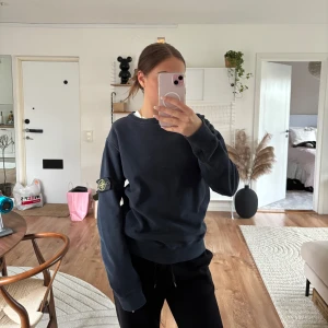 Mörkblå sweatshirt från Stone Island - Säljer en mörkblå sweatshirt från Stone Island med klassisk patch på vänster ärm. Tröjan har rund halsringning och långa ärmar. Perfekt för en avslappnad och stilren look.