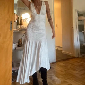 Vit långklänning med prickigt mönster  - Säljer en vit långklänning med små svarta prickar och djup v-ringning. Klänningen har breda axelband. Super söt helt oanvänd jättegullig och unik 🖤🤍🖤