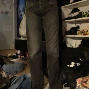 Grå bootcut jeans - Säljer ett par gråa jeans med bootcut passform. Klassisk femficksmodell med knapp och dragkedja framtill. Jeansen har en något utsvängd benslut och normal midja. Perfekta för dig som gillar en tidlös stil.