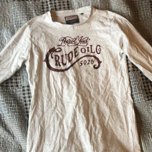 Vit långärmad tröja från Petrol Industries - Vit långärmad tröja från Petrol Industries med tryck i vinrött framtill. Tröjan har rund halsringning och är tillverkad i mjukt bomullsmaterial. Perfekt för en avslappnad stil.