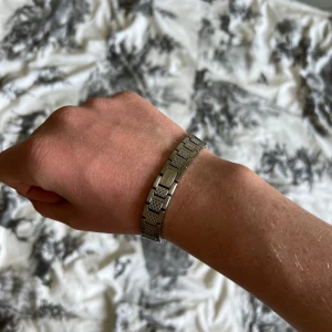 Lacoste armband - Snyggt armband i silverfärgat rostfritt stål med rektangulära länkar och ett diskret mönster på vissa av länkarna. Perfekt accessoar för att lyfta din stil med en modern och stilren touch. Lacoste nypris 1000