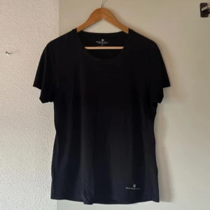 Svart t-shirt från Ronhill - En svart tränings t-shirt från Ronhill med rund hals och diskret logga nere vid fållen. Perfekt för träning eller vardag. Klassisk passform och korta ärmar.☺️💓 Den är i storlek M men skulle även säga den passar S.