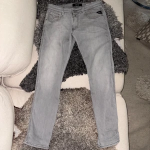 Ljusgrå Replay Anbass jeans - Säljer ett par ljusgrå Replay Anbass jeans med klassisk femficksdesign. Storlek är 32 o 32, passar folk som är runt 180 cm