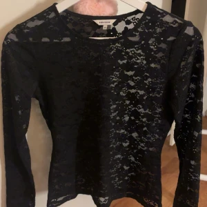 Svart spetsblus från bubbleroom - Säljer en svart långärmad blus i spets från bubbleroom.  Perfekt för dig som vill ha en elegant och trendig topp.