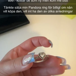 Silverring med hjärta från Pandora - Säljer en stilren silverring från Pandora med ett glittrigt hjärta i mitten. Ringen har små stenar runt hela bandet och är perfekt för dig som gillar eleganta smycken med det lilla extra. Ja vill sälja den på grund av att ja fick de av mitt ex o vill ba bli av med den, har aldrig använt den,kom med bud.