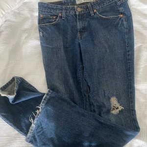 Levis jeans med slitningar - Bootcut levis jeans med slitningar vid knäet. Inga defekter förutom lite slitningar längst ner men inget som man tänker på.💞 midjemått ramt öcer är 41 cm