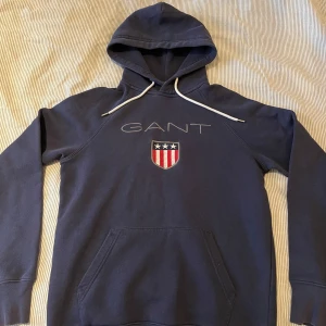 Marinblå Gant hoodie - Säljer min marinblåa Gant hoodie i storlek S. Den är knappt använd och inga defekter förekommer. Skriv för fler bilder. 