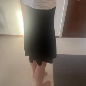 Svart sammetskjol från KappAhl - Säljer en svart sammetskjol från KappAhl i storlek 36. Kjolen har en lätt utsvängd form och dragkedja bak för enkel påklädning. Perfekt för dig som gillar klassisk och stilren look.