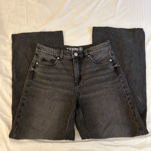 Svarta wide leg jeans från Denim 1953 - Säljer ett par svarta jeans från Denim 1953 i storlek 38. Byxorna har en breda ben och  klassiska fem fickor och knappgylf samt medel hög midja. 