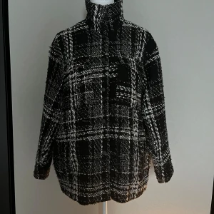 Svartvit rutig overshirt med knappar - Säljer en oversized svart och vit rutig overshirt med hög krage och knäppning framtill. 